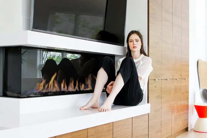 Coco Rocha in front of her new corner-style modern gas fireplace by Element4