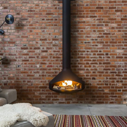 Paxfocus modern wood fireplace against an exposed brick wall
